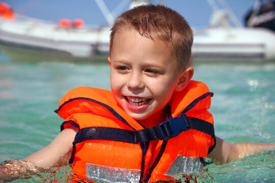 a boy in a life jacket at sea