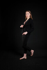 image of a model girl in a black suit on a black background