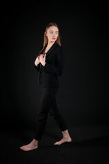 image of a model girl in a black suit on a black background