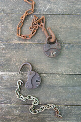Steampunk style two old rusty padlock and rusty chain on wooden background. High quality photo