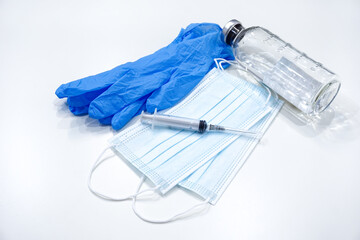 medical mask, syringe, blue medical gloves and a bottle with vaccine