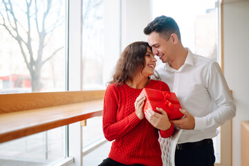 Young couple with gift box hugging and celebrating Valentine's Day. Relationship, holiday, ...