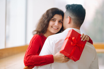 Young couple with gift box hugging and celebrating Valentine's Day. Relationship, holiday, ...