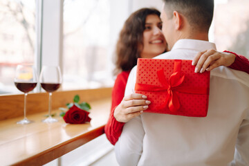 Young couple with gift box hugging and celebrating Valentine's Day. Relationship, holiday,  surprise and love concept.