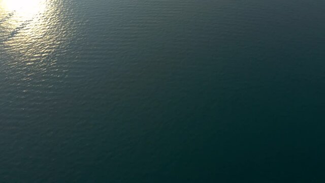 Tilt up aerial shot revealing the famous tourist location Isola del Garda from Garda Lake, Italy