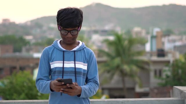 Portrait of an Indian kid wearing glasses using tablet, Kid watching online videos, Kid uses internet to learn new things, Online Education concept, New normal in Education