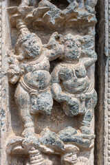 Lakkundi, Karnataka, India - November 6, 2013: Kasivisvesvara Temple, Gray stone missing legs dancing couple sculpture on outside wall.