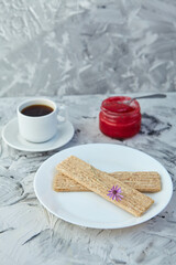 Crispbread with jam for Breakfast on a gray background. A jar of Fresh Honey with foam is next to a Cup of coffee. A minimum of calories. proper nutrition