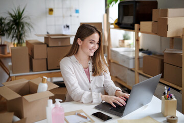 Young woman dropshipper with laptop working at home, coronavirus concept.