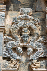 Fototapeta na wymiar Lakkundi, Karnataka, India - November 6, 2013: Kasivisvesvara Temple. Closeup of non-figurative gray-beige stone sculpture on outside wall.