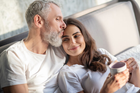 Couple having morning coffee in the bed