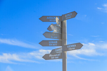 Sign indicating the directions and distances to major cities in the world on observation deck on a top of Tahtali mountain near Kemer, Antalya Province in Turkey
