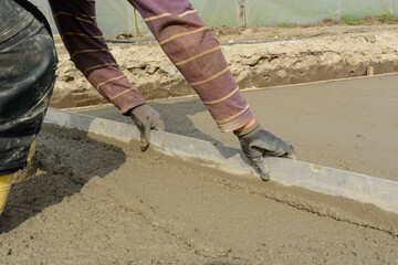 Bricklayer On Construction Site With Straightedge - Concrete