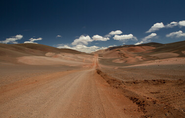 The dirt road high in the Andes mountains. Traveling along the route across the arid desert and mountain range. The sand and death valley under a deep blue sky in La Rioja, Argentina.