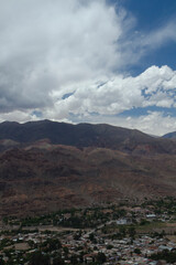 Fototapeta na wymiar View of Humahuaca ravine, the rocky Andes mountains and Tilcara village under a cloudy sky in Jujuy, Argentina. 