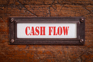 Fototapeta premium cash flow - a label on grunge wooden file cabinet, business and finance concept