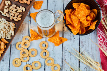 Assorted snacks, chips, and beer on blue table. Table for group of friends