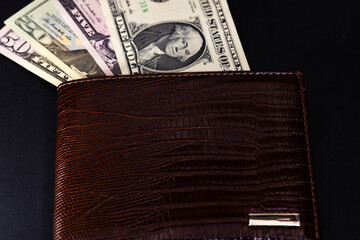 Paper american dollars in brown wallet, close up, selective focus