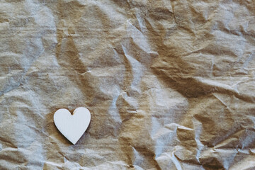 Un coeur en bois sur un fond papier froissé avec espace vide - Arrière plan Saint-Valentin