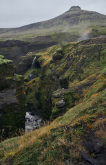 Fototapeta na wymiar Mountain route around a cliff and a river. Skogafoss waterfall
