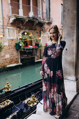 The girl walks through the narrow streets. A tourist travels around Venice.