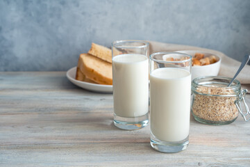 Fresh milk, oatmeal and bread on a gray background. Side view with copy space. The concept of proper nutrition.