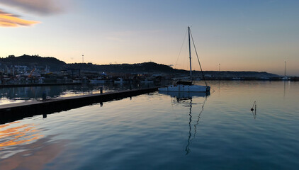 Obraz premium Barca a vela ormeggiata al molo nella luce del tramonto