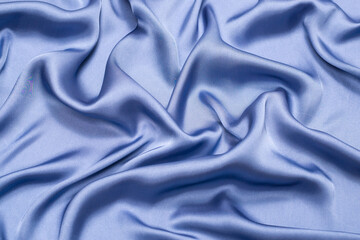 Blue silk or satin luxury fabric texture. Top view.