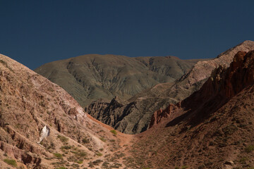 Arid landscape. View of the desert, rock minerals and colorful mountains under a blue sky. 