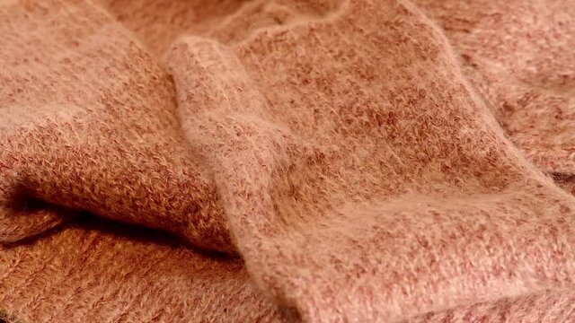 Pinker Mohair Pullover auf einem Drehteller als Hintergrund