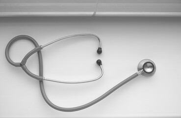 Fototapeta na wymiar Stethoscope medical diagnostic device on a table near a window with blinds.