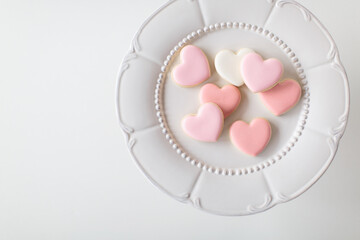 pink heart sugar cookies on white decorative plate, offset