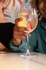Ecuadorian boy in fisherman's cap poses with his drink, behind him is a background of tropical palm trees.