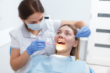Young woman getting her teeth checked by dentist