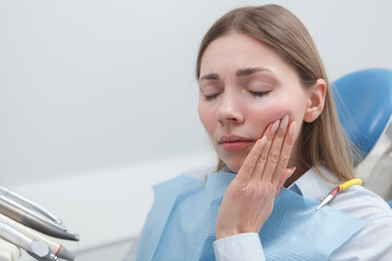 Young woman suffering from toothache waiting for dental treatment at the clinic