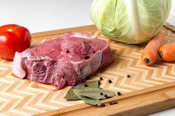 Ingredients for Soup on a cutting board Raw Meat Beef Head of Cabbage Carrot Tomato White background Isolate Copy space