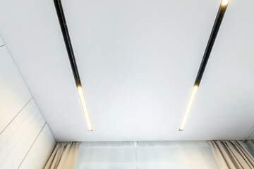suspended ceiling with halogen spots lamps and drywall construction in empty room in apartment or...