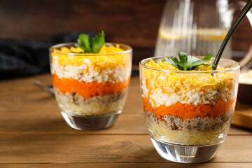 Traditional russian salad Mimosa served on wooden table