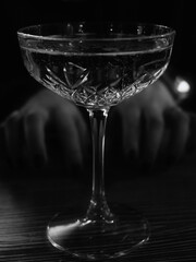 Hands reach for a glass of champagne black and white photo.