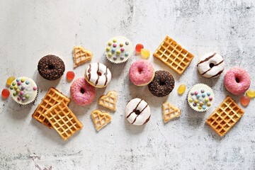 Flat layot from  festive dessert table with various of waffles, cake, muffins and sweets. Flat layot, copy space