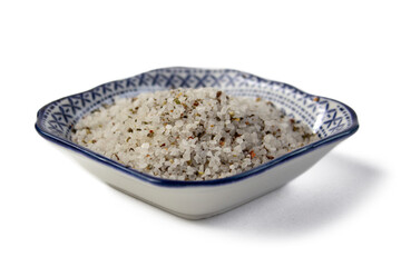 Spices, white, black and red peppers, sea salt on ornamental plate on a white background, close-up, isolated