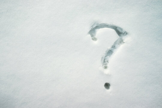 Handwritten question mark on snow surface.