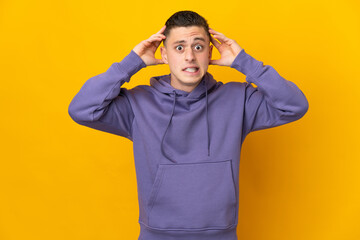 Young caucasian man isolated on yellow background doing nervous gesture