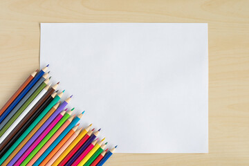 Obraz premium Colorful pencils with blank white paper on the table.