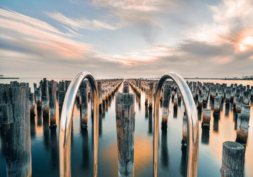 Looking into the sunset horizon of the old wooden pylons of historic princes pier in Port Melbourne, Australia.