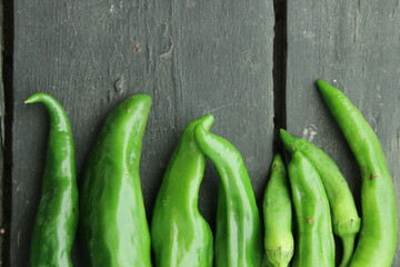 Green hot pepper in wooden plate closeup. Food photography