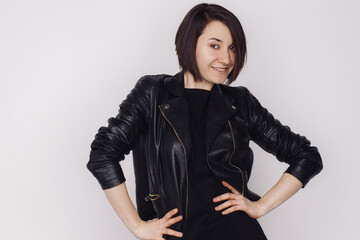 Portrait of smiling female in a black sweater and black jacket isolated on white background.