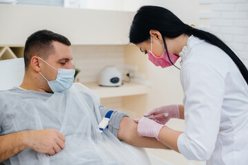 Obraz premium A man's blood is taken from a vein for analysis and testing for viruses. The formation of the immune system and antibodies.