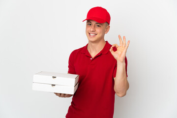 Pizza delivery man with work uniform picking up pizza boxes isolated on white background showing ok sign with fingers