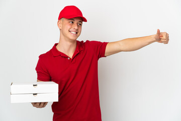Pizza delivery man with work uniform picking up pizza boxes isolated on white background giving a...